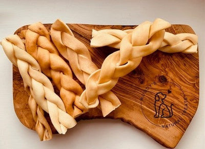 Anco Naturals Beef Braids medium braided dog chew treats on wooden board